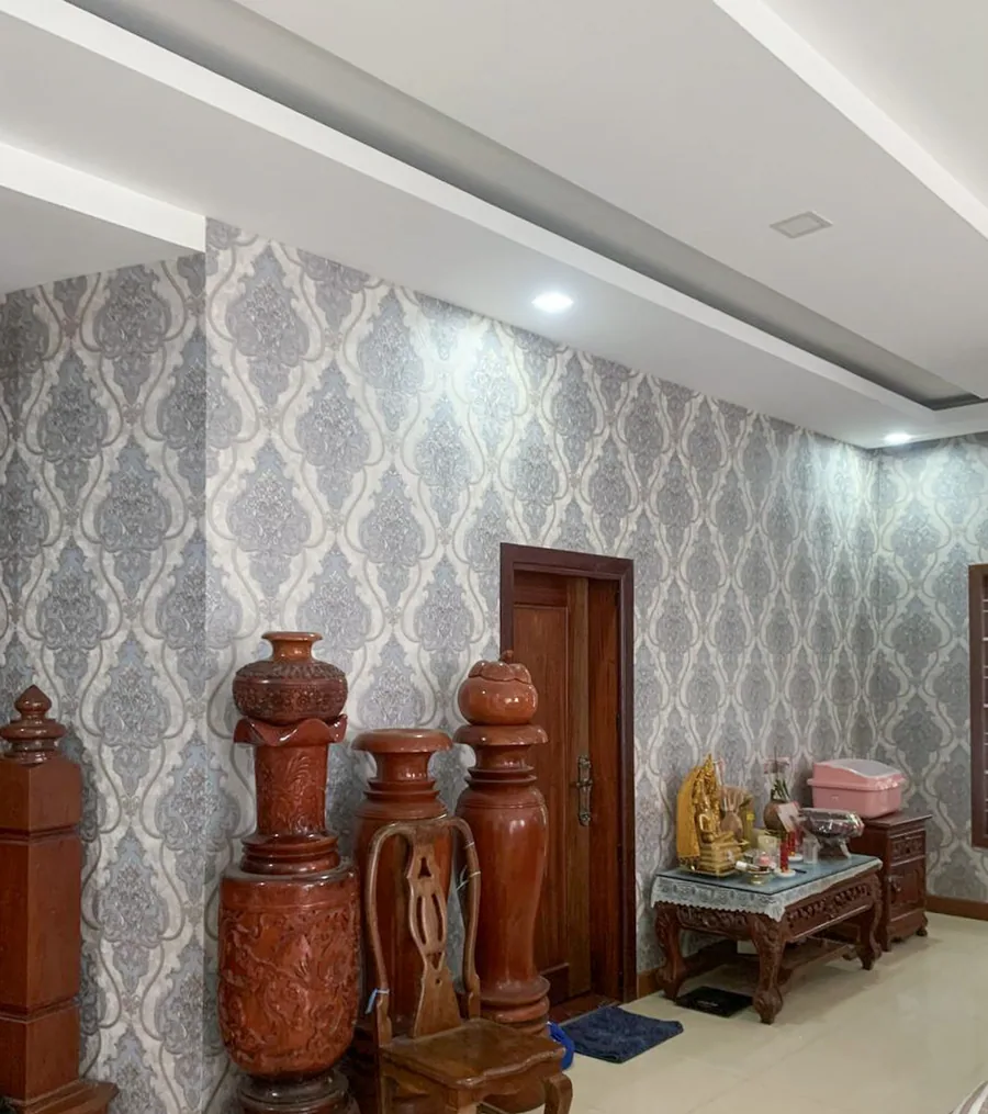 A wall finished in patterned damask wallpaper